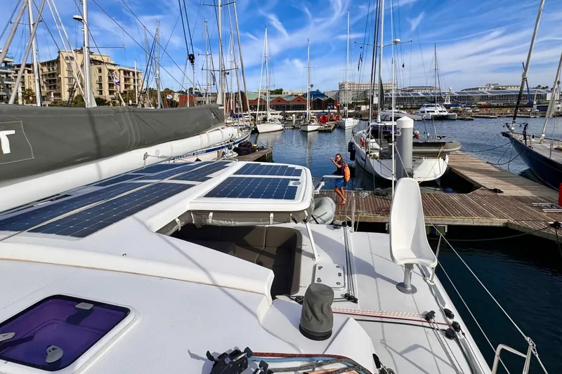 Slide: The Image of 2017 Outremer 51 catamaran docked at marina with solar panels and clear blue sky. - 26