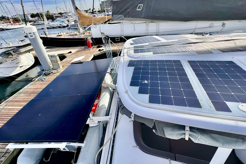 Slide: The Image of 2017 Outremer 51 catamaran with solar panels docked at a marina. - 27