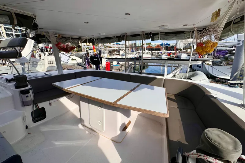 Slide: The Image of Spacious cockpit of 2017 Outremer 51 catamaran with seating and table, docked at marina. - 31