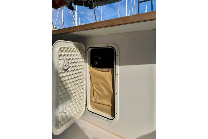 Slide: The Image of Open storage compartment on 2017 Outremer 51 sailboat, featuring a beige interior pouch. - 32