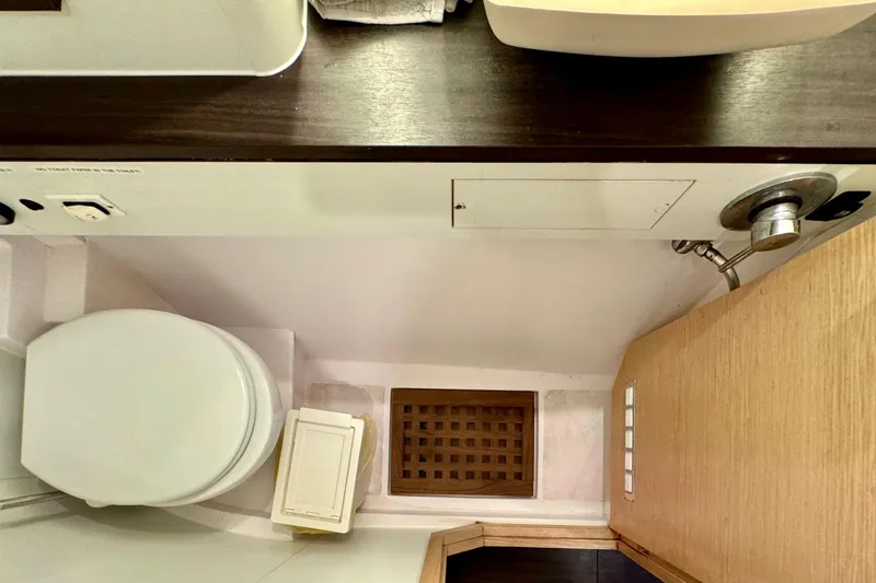 Slide: The Image of Bathroom interior of 2017 Outremer 51 yacht, featuring toilet and wooden cabinetry. - 49
