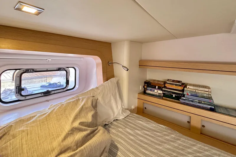 Slide: The Image of Cozy cabin interior of 2017 Outremer 51 yacht with books and window view. - 64