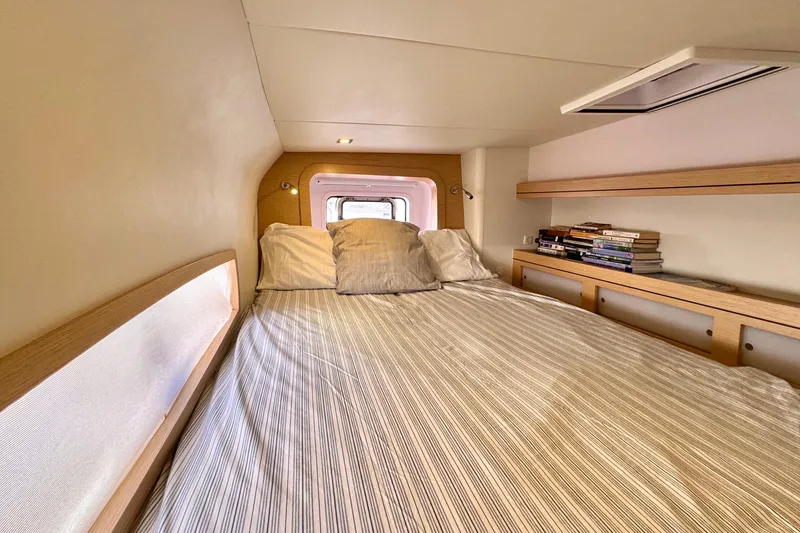 Slide: The Image of Cozy cabin interior of 2017 Outremer 51 yacht with bed and bookshelf. - 68