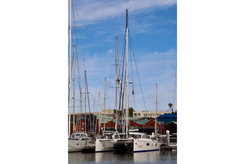 Slide: The Image of 2017 Outremer 51 catamaran docked in a marina under a clear blue sky. - 76