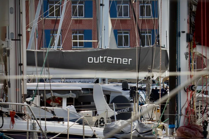 Slide: The Image of 2017 Outremer 51 catamaran docked in marina, surrounded by rigging and buildings. - 77
