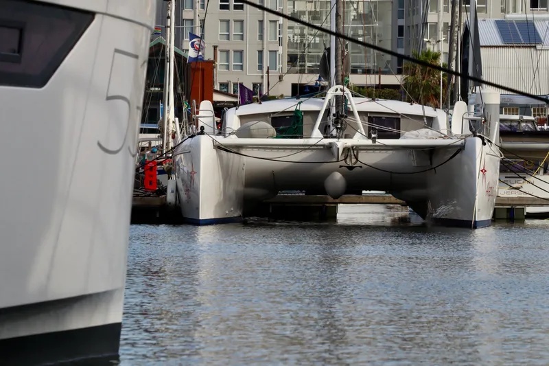 Slide: The Image of 2017 Outremer 51 catamaran docked in a marina, surrounded by buildings. - 8
