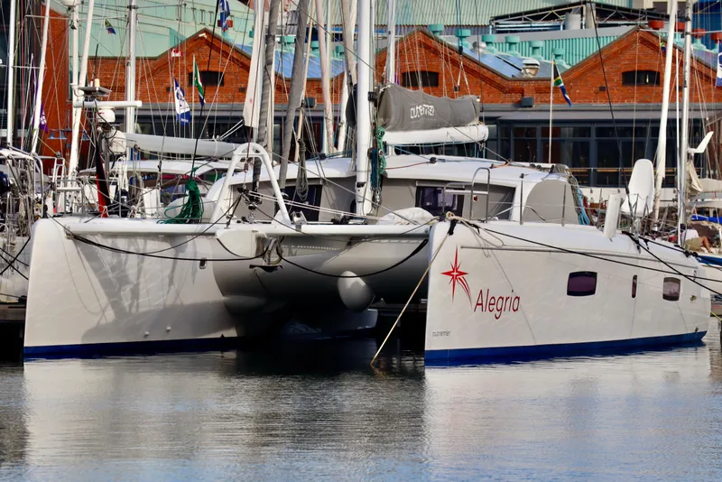 Slide: The Image of 2017 Outremer 51 catamaran "Alegria" docked at a marina with other sailboats. - 9