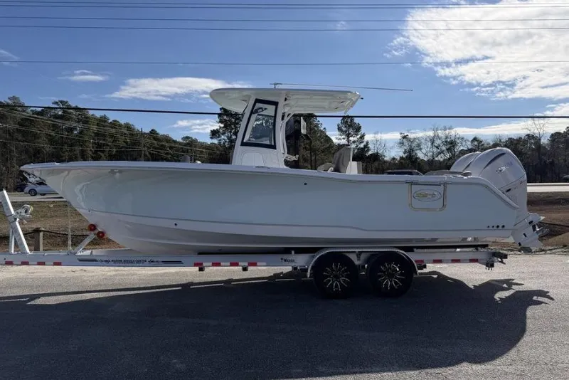 The Image of 2026 Sea Hunt Ultra 275 SE boat on trailer, side view under clear sky. - 1