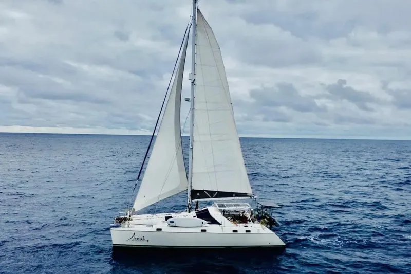 Slide: The Image of Sailing catamaran Privilege 482, 1992 model, cruising on open ocean under cloudy skies. - 0