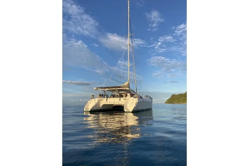 Slide: The Image of Sailing catamaran Privilege 482, 1992 model, on calm ocean waters under a blue sky. - 1