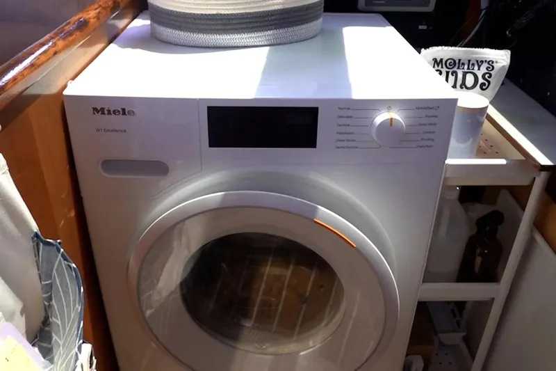 Slide: The Image of A Miele washing machine in a cozy laundry space, with a Privilege 482 model from 1992 nearby. - 26