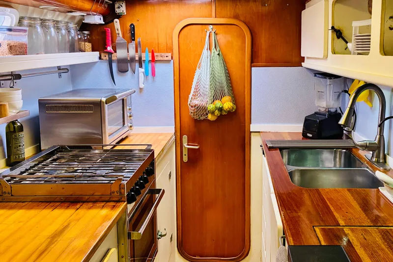 Slide: The Image of Compact kitchen in a 1992 Privilege 482 yacht with wooden countertops and modern appliances. - 28