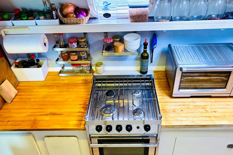 Slide: The Image of Kitchen with stove, toaster oven, spices, and wooden countertop in Privilege 482, 1992 model. - 29