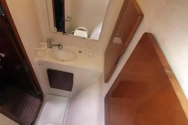 Slide: The Image of Bathroom interior of 1992 Privilege 482 yacht, featuring sink, mirror, and wooden accents. - 6