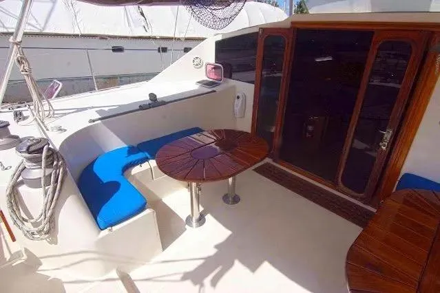 Slide: The Image of Deck of 1992 Privilege 482 yacht with blue seating and wooden tables. - 7