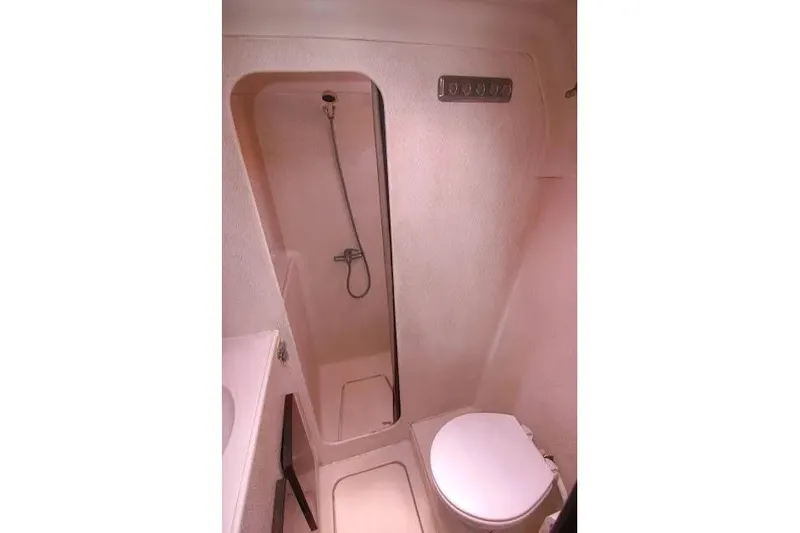 Slide: The Image of Compact bathroom in a 1992 Privilege 482 yacht, featuring a shower and toilet. - 9