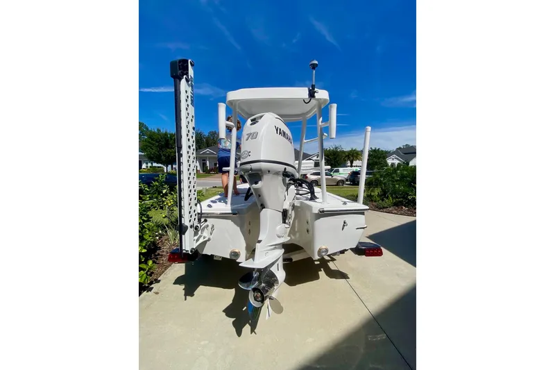 Slide: The Image of 2026 Chaos 16 Bonefish boat with Yamaha engine, parked on driveway under clear blue sky. - 2