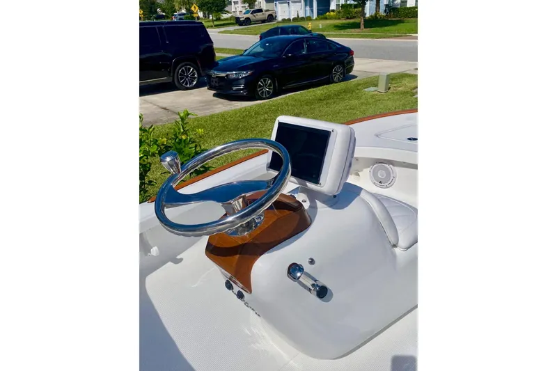 Slide: The Image of 2026 Chaos 16 Bonefish boat dashboard with steering wheel and navigation display. - 3