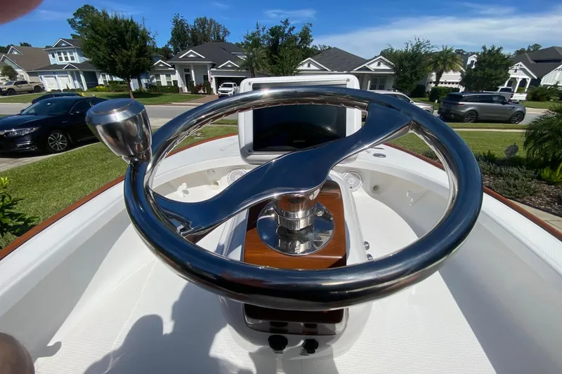Slide: The Image of Steering wheel of 2026 Chaos 16 Bonefish boat, parked in a residential neighborhood. - 5