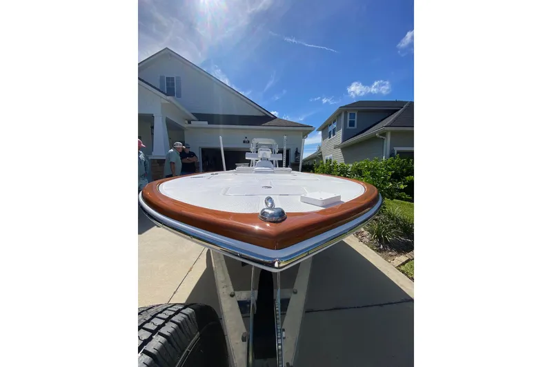 Slide: The Image of 2026 Chaos 16 Bonefish boat on trailer in residential driveway under sunny sky. - 7