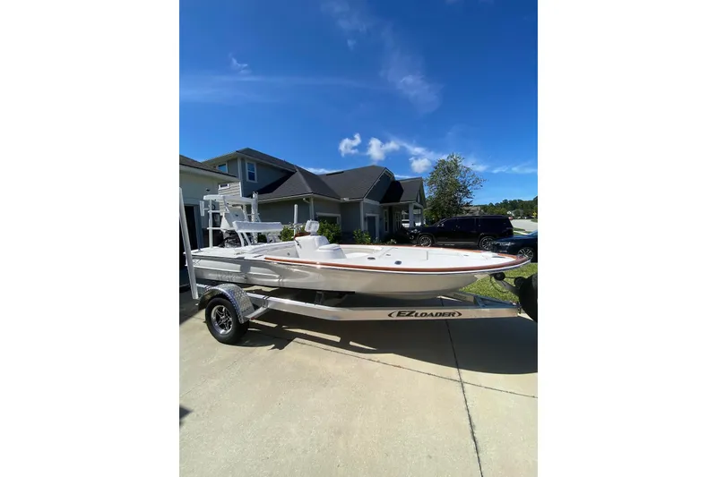Slide: The Image of 2026 Chaos 16 Bonefish boat on trailer in residential driveway under clear blue sky. - 8