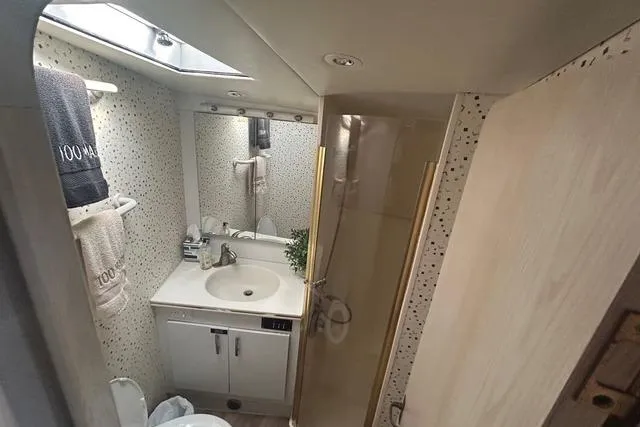 Slide: The Image of Bathroom interior of a 1995 Ocean 53 Super Sport yacht, featuring a sink and shower. - 11