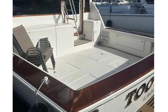 Slide: The Image of 1995 Ocean 53 Super Sport boat deck with stacked chairs and storage compartments. - 14