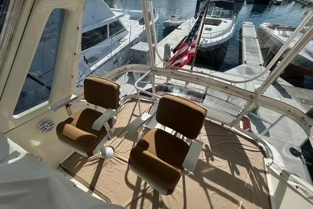 Slide: The Image of 1995 Ocean 53 Super Sport yacht interior with two brown chairs, docked at marina. - 21