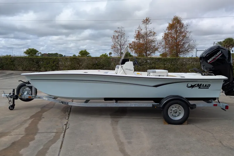 The Image of 2026 Mako Pro Skiff 17 CC boat on trailer, parked outdoors under cloudy sky. - 0