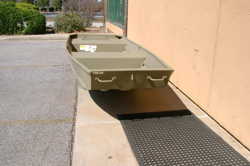 Slide: The Image of 2026 Tracker Grizzly 14 Jon boat on pavement near a building. - 3