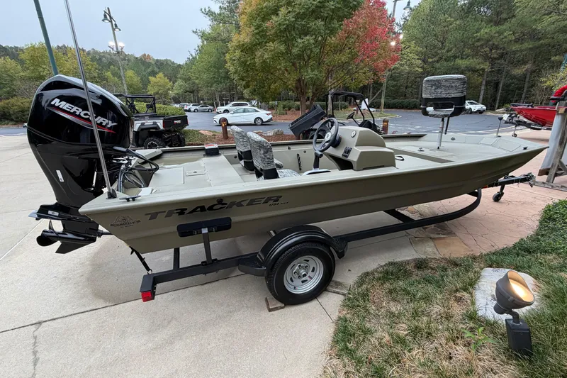 The Image of 2026 Tracker Grizzly 1754 SC boat with Mercury engine on trailer, parked outdoors. - 0
