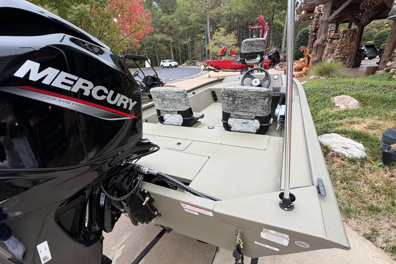 Slide: The Image of 2026 Tracker Grizzly 1754 SC boat with Mercury FourStroke engine, parked outdoors. - 2