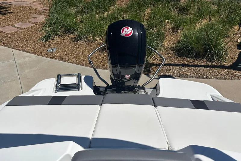 Slide: The Image of 2026 Tahoe T18 boat with outboard motor and swim platform, parked on pavement. - 12