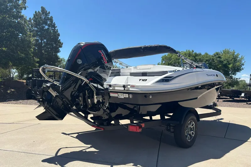 Slide: The Image of 2026 Tahoe T18 boat on trailer, featuring powerful outboard motor, parked outdoors. - 2