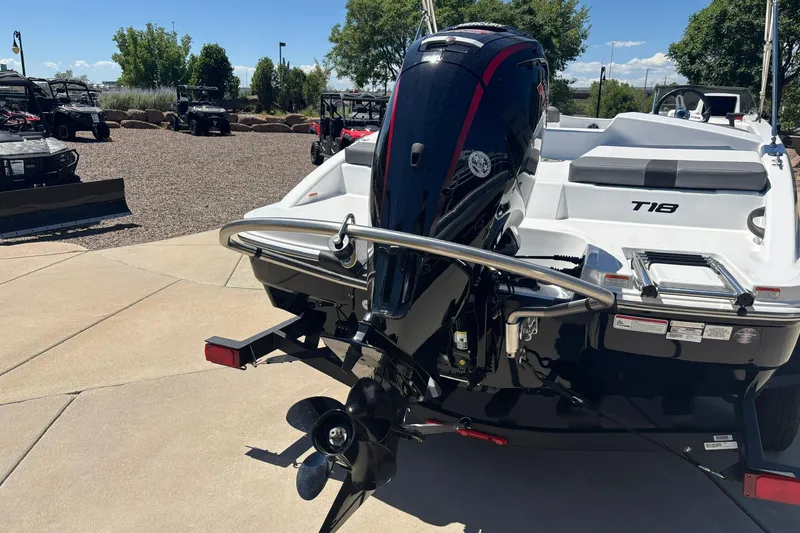 Slide: The Image of 2026 Tahoe T18 boat with outboard motor, parked outdoors on a sunny day. - 13