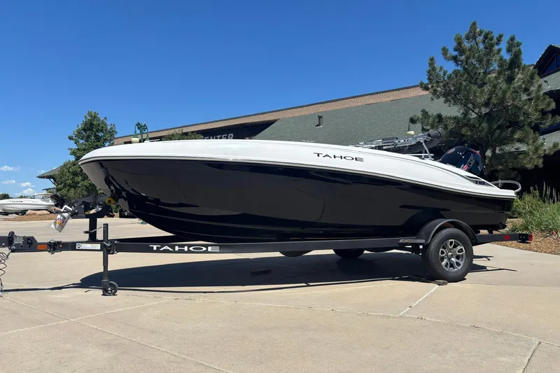 The Image of 2026 Tahoe T18 boat on trailer, parked outdoors under clear blue sky. - 0