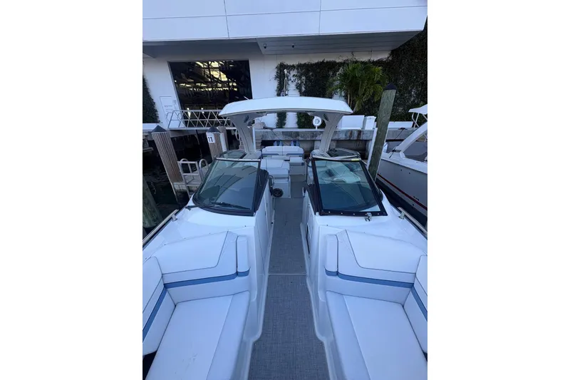 Slide: The Image of 2024 Formula 310 Bowrider OB with spacious seating and sleek design at a marina. - 16