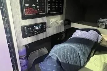 Slide: The Image of 2024 Formula 310 Bowrider OB cabin interior with control panels and bedding. - 19