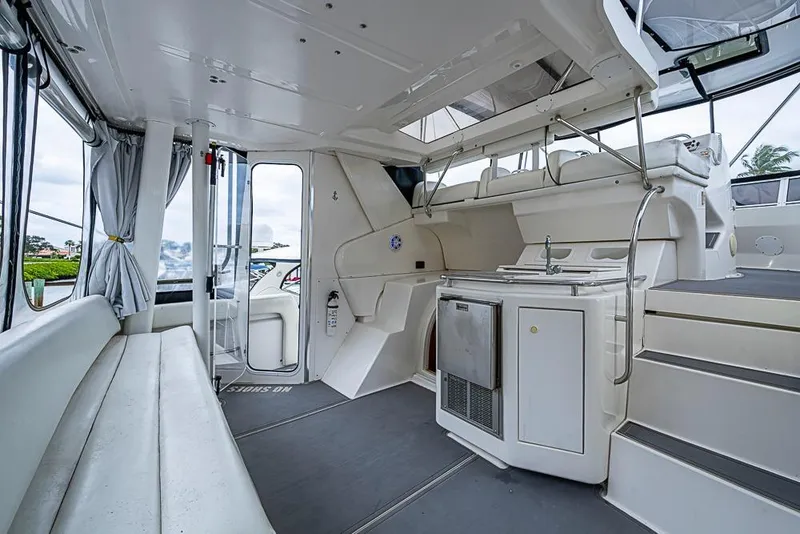 Slide: The Image of 2000 Silverton 442 Cockpit Motor Yacht interior with seating, kitchenette, and stairs. - 13