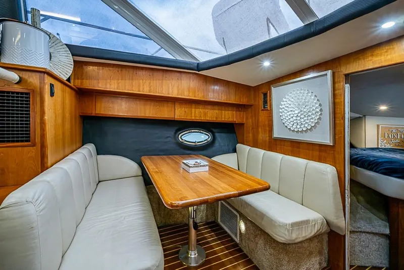 Slide: The Image of Luxurious interior of 2000 Silverton 442 Cockpit Motor Yacht with elegant seating and wooden table. - 17