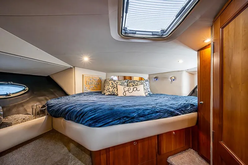 Slide: The Image of Luxurious bedroom interior of 2000 Silverton 442 Cockpit Motor Yacht with skylight and cozy bedding. - 28