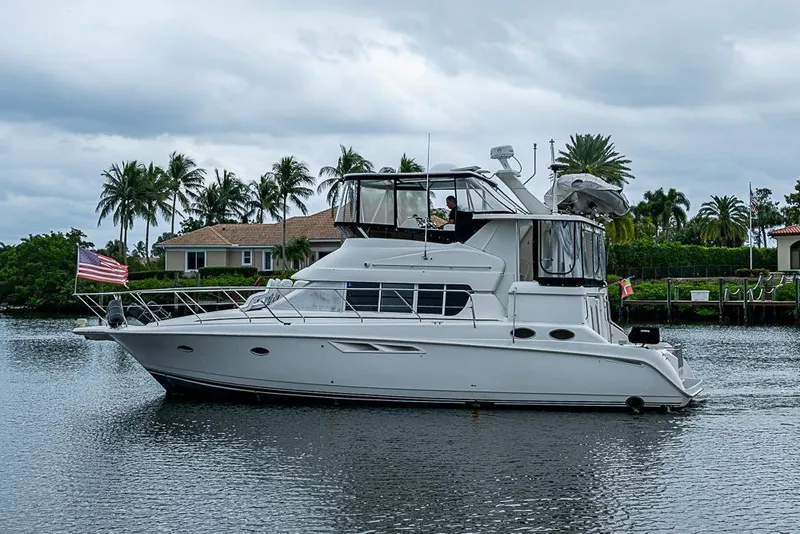 Slide: The Image of 2000 Silverton 442 Cockpit Motor Yacht on a calm waterway with palm trees. - 32