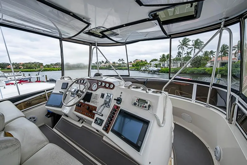 Slide: The Image of Cockpit view of 2000 Silverton 442 Cockpit Motor Yacht with modern controls and scenic waterfront. - 7