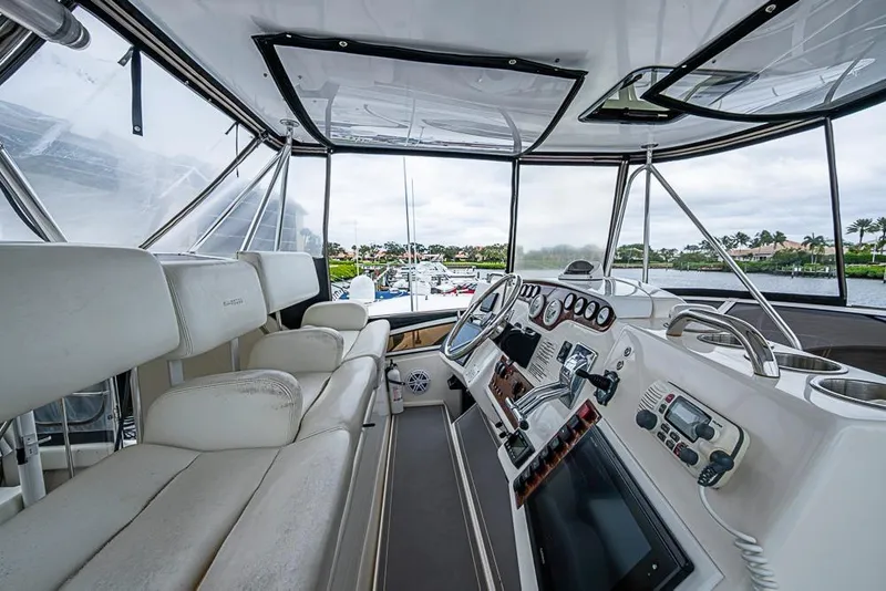 Slide: The Image of Interior view of 2000 Silverton 442 Cockpit Motor Yacht helm with luxurious seating and controls. - 9