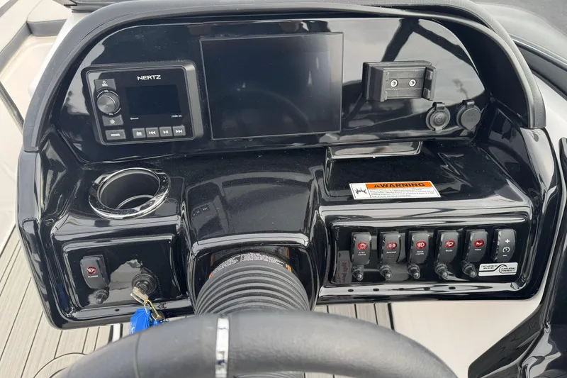 Slide: The Image of 2024 Yamaha Boats 195S dashboard with controls, display, and cup holder. - 17