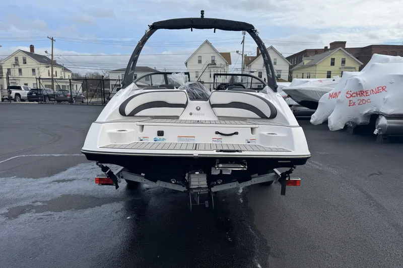 Slide: The Image of 2024 Yamaha Boats 195S, rear view, parked on asphalt with residential background. - 25