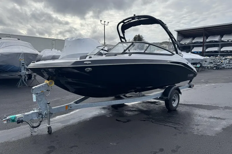 Slide: The Image of 2024 Yamaha Boats 195S on trailer, parked outdoors under cloudy sky. - 3