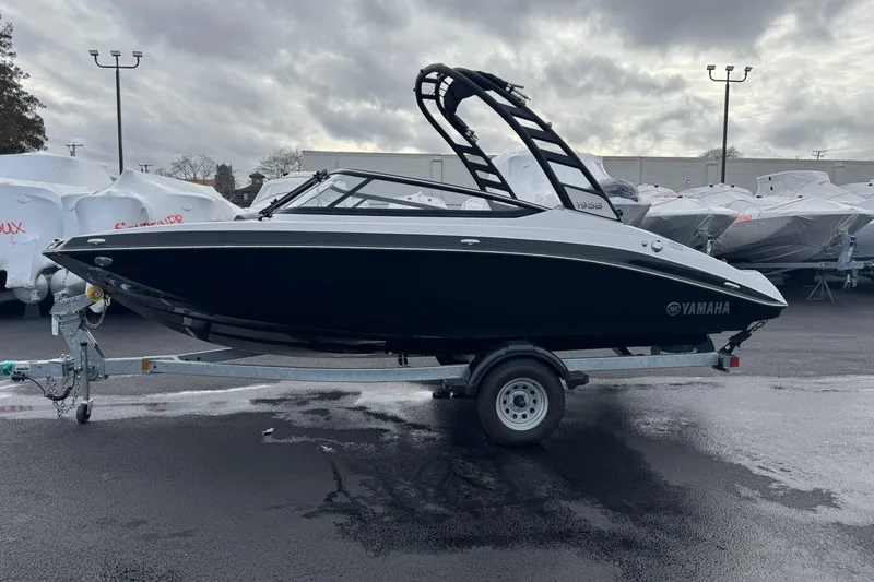 Slide: The Image of 2024 Yamaha Boats 195S on trailer, parked outdoors under cloudy sky. - 4