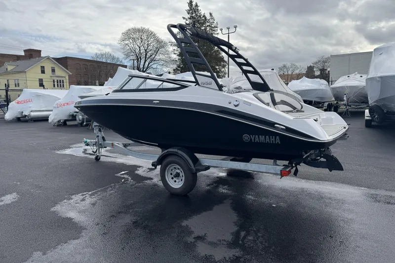 Slide: The Image of 2024 Yamaha Boats 195S on trailer in parking lot, overcast sky. - 5