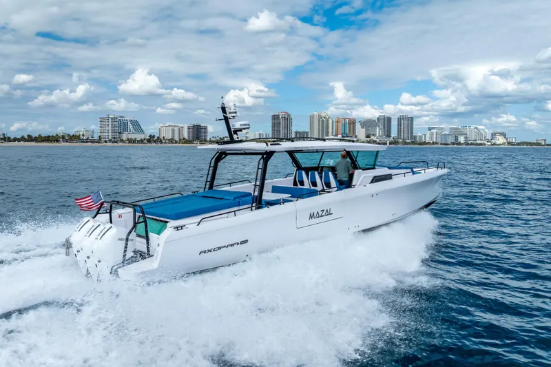 Slide: The Image of 2025 Axopar 45 Cross Top cruising near city skyline on a sunny day. - 16